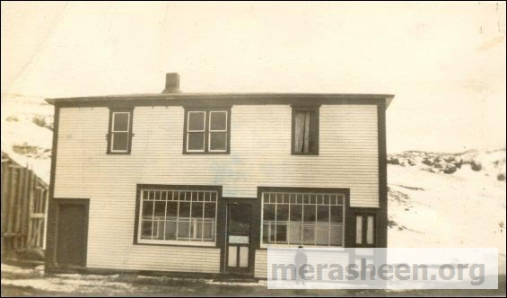 The "new" Co-op store in 1949 with a 6-years old Ernie Walsh.&amp;nbsp;&amp;nbsp;By 1946, Co-op number three had become too small and at a board meeting in October 1946, they decided to build this larger store. John J Ennis and James Connors accepted the job of lead hands and were to be paid the grand sum of thirty-five cents an hour, helpers were to be paid a princely thirty cents an hour. At a board meeting in March 1947, a motion was passed that Co-op number three be closed April 4 and April 5 to facilitate the movement of inventory to the new building. The Co-op store opened for it's first day of business on April 7,1947.&amp;nbsp;To the left are the remains of the old parish hall down stairs and school up-stairs, shown by the old vertical sticks and the sloped roof.